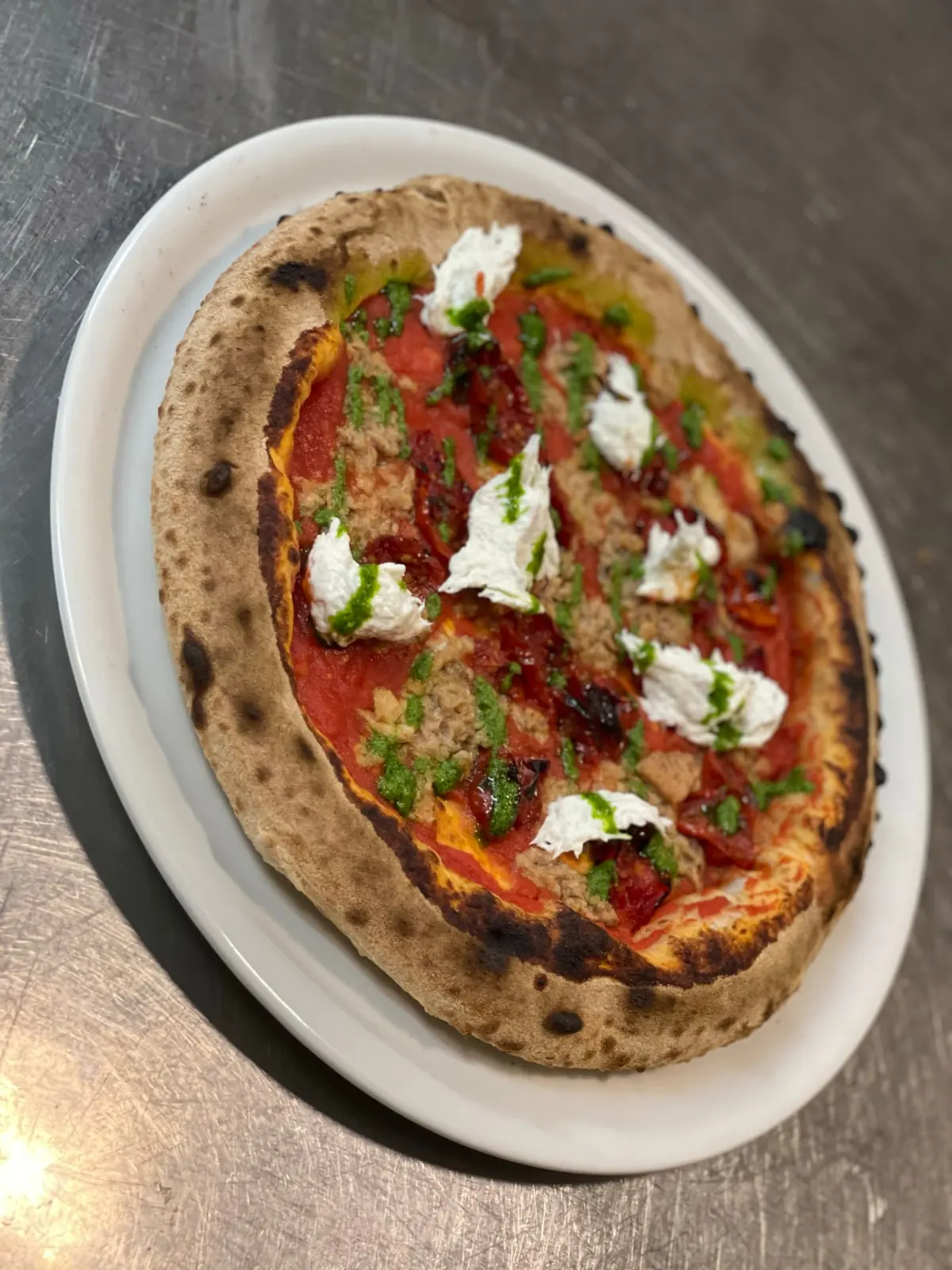 Pizza Back-e-ton del Ristò Italia con tonno sott'olio, baccalà, pomodorini confit e salsa al basilico